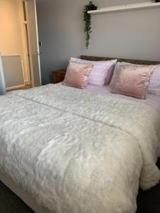 a bedroom with a large white bed with pink pillows at My Perfect Place Rooms & Apartments -Some rooms with Hot Tub- Free Parking in Blackpool