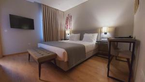 um quarto de hotel com uma cama grande e uma cadeira em Casa da Torre - Viseu em Viseu