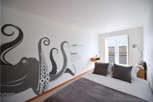 a bedroom with a bed with an octopus mural on the wall at Casa da Baía - Guest House in Horta