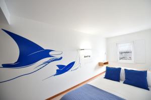 a bedroom with a whale mural on the wall at Casa da Baía - Guest House in Horta