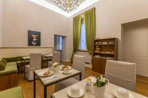Dimora Storica Lo Svevo في ليسي: غرفة معيشة مع طاولات وكراسي وغرفة طعام