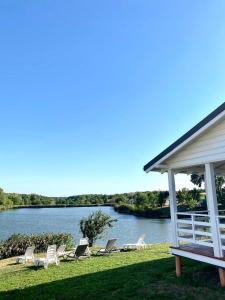 a group of chairs and a gazebo next to a lake at Balka Eco Club in Glubokaya Balka