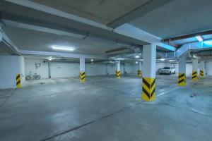 シフィノウイシチェにあるApartamenty na Wyspie - Stella Baltic - Parkingの黄色と白の柱の空の駐車場