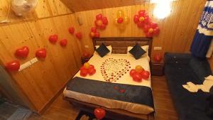 Cette chambre comprend un lit avec des ballons sur le mur. dans l'établissement Ibni Springs, à Madikeri