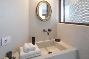 a bathroom with a sink with a mirror and towels at La Casa di Melo - Organic Farm in Cassibile
