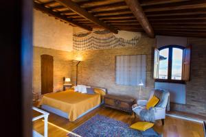 a bedroom with a bed and a chair in a room at Zafferano Rooftop Terrace Tower House in San Gimignano