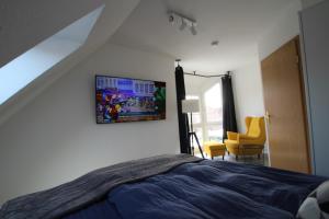 a bedroom with a bed and a picture on the wall at Ferienhaus Seebrise in Neßmersiel