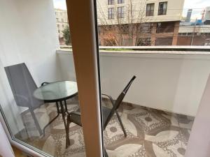 a balcony with a table and a glass window at Center Loft in Buzău