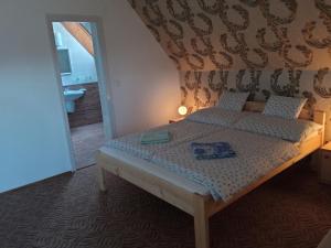 a bedroom with a bed and a bathroom with a mirror at Holiday Apartmanház in Zalakaros