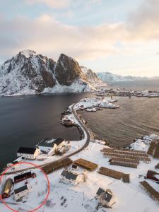 a winter view of a harbor with snow covered mountains at Anitas Waterfront Cabins in Reine