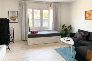 ein Wohnzimmer mit einem Bett und einem Fenster in der Unterkunft Toppmodern familjelägenhet nära Kalmar slott och långviksbadet in Kalmar