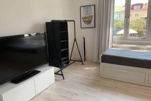 Schlafzimmer mit einem Flachbild-TV und einem Bett in der Unterkunft Toppmodern familjelägenhet nära Kalmar slott och långviksbadet in Kalmar