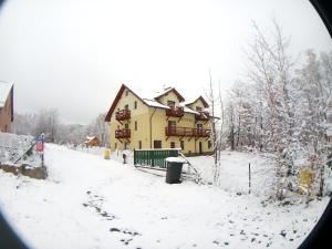a house covered in snow in front at Sasanka in Karpacz