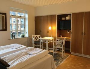 1 dormitorio con 1 cama, mesa y sillas en Herligheden, en Bjerringbro