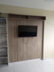 a flat screen tv on a wooden wall at Apartamento em Praia Grande in Praia Grande