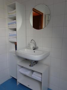y baño con lavabo, espejo y toallas. en Kamerverhuur Advenco, en Aagtekerke