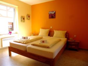sypialnia z 2 łóżkami i pomarańczową ścianą w obiekcie Ferienhaus Alte Mühle w mieście Zell an der Mosel