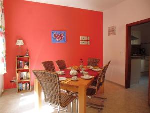 stół jadalny z krzesłami i czerwoną ścianą w obiekcie Ferienhaus Alte Mühle w mieście Zell an der Mosel