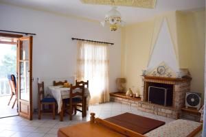- un salon avec une cheminée et une table dans l'établissement Pine tree house, à Troulos