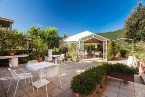 d'une terrasse avec une table, des chaises et un kiosque. dans l'établissement Villa Primavera - Homelike Villas, à Capoterra