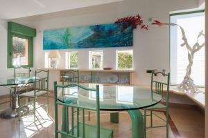 une salle à manger avec une table et des chaises en verre dans l'établissement Villa Primavera - Homelike Villas, à Capoterra