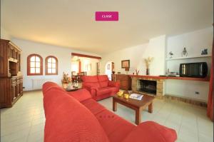 Una sala de estar con un sofá rojo y una mesa. en Villa Marions, en Santanyí