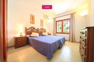 Un dormitorio con una cama azul y una ventana. en Villa Marions, en Santanyí 14 fotos más