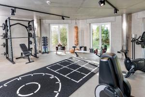 a gym with a weight room with a treadmill at Hotel und Spa Lundenbergsand in Simonsberg