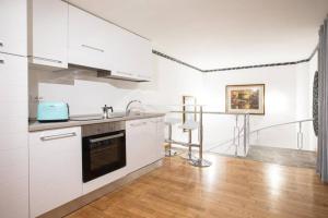 a white kitchen with a sink and a stove at Unforgettable Split Level Jacuzzi Suite Navona - Top Collection in Rome