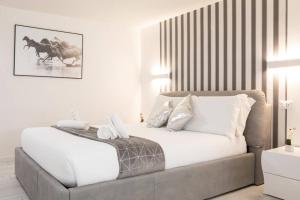 a white bedroom with a large bed with white pillows at Unforgettable Split Level Jacuzzi Suite Navona - Top Collection in Rome