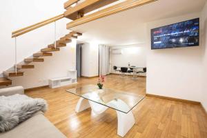 a living room with a glass table and a staircase at Unforgettable Split Level Jacuzzi Suite Navona - Top Collection in Rome