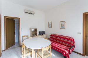 een witte kamer met een tafel en een rode deken bij Villa Generosa in Lido di Jesolo