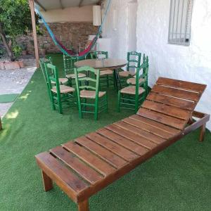 un banco de madera sentado junto a una mesa y sillas en Casa Rural ¨Villa Vivares¨ 3*, en Miajadas
