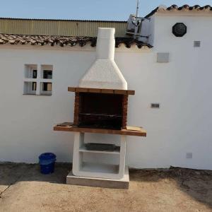 una estufa blanca sentada frente a un edificio en Casa Rural ¨Villa Vivares¨ 3*, en Miajadas