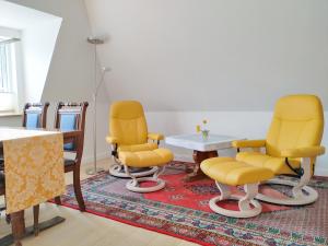 Zimmer mit gelben Stühlen, einem Tisch und einem Tisch in der Unterkunft Ferienwohnung Gül Waanang in Nebel