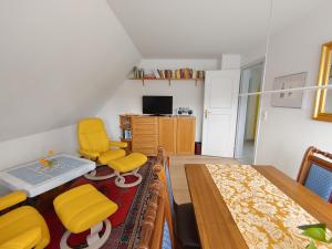 ein Schlafzimmer mit gelben Stühlen, einem Tisch und einem Bett in der Unterkunft Ferienwohnung Gül Waanang in Nebel