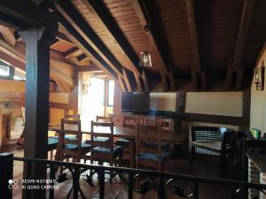 a dining room with a table and chairs and a tv at la felicidad de la tierra in Torija