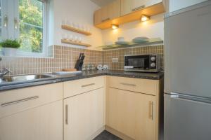 cocina con fregadero y microondas en Stylish Apartment with Private Parking en Cardiff