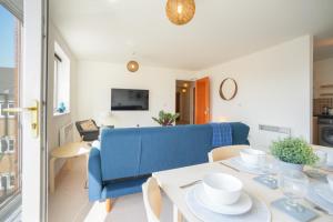 a living room with a blue couch and a table at Stylish Apartment with Private Parking in Cardiff