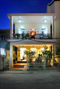a large white building with a balcony at night at Cosy House Homestay in Hoi An
