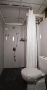 ein Badezimmer mit einem weißen WC und einer Dusche in der Unterkunft Hotel Raj Resort in Margao