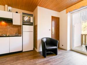 ラ・ブレスにあるSpacious Apartment in La Bresse with Terraceの窓付きのキッチン(黒い椅子付)