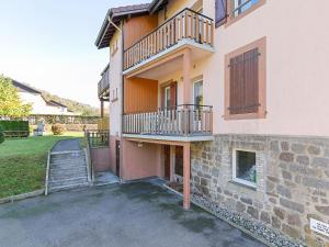 ラ・ブレスにあるSpacious Apartment in La Bresse with Terraceの階段とバルコニー付きの家