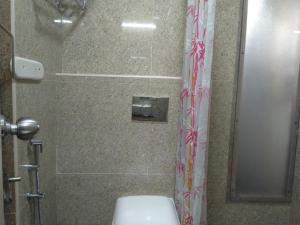 a bathroom with a shower with a toilet and a shower curtain at Chandru De Green in Chennai