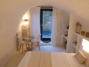 een kamer met een bed, een tafel en een raam bij le tilleul in Villevieille