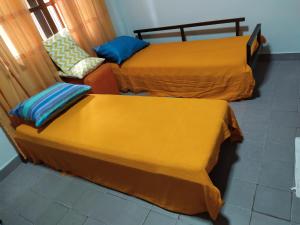 two beds with yellow covers in a room at Departamento centrico en Posadas, garage opcional D2 in Posadas