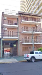 a white truck parked in front of a building at Departamento centrico en Posadas, garage opcional D2 in Posadas