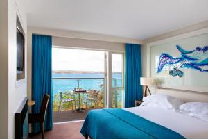 Schlafzimmer mit einem Bett und Meerblick in der Unterkunft Cliff House Hotel in Ardmore