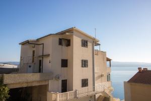 a building with a balcony and the ocean in the background at Leonarda in Omiš