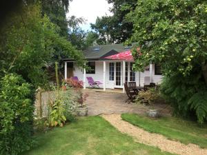 a small white house with a patio and chairs at Sailaway perfect romantic break in Norwich